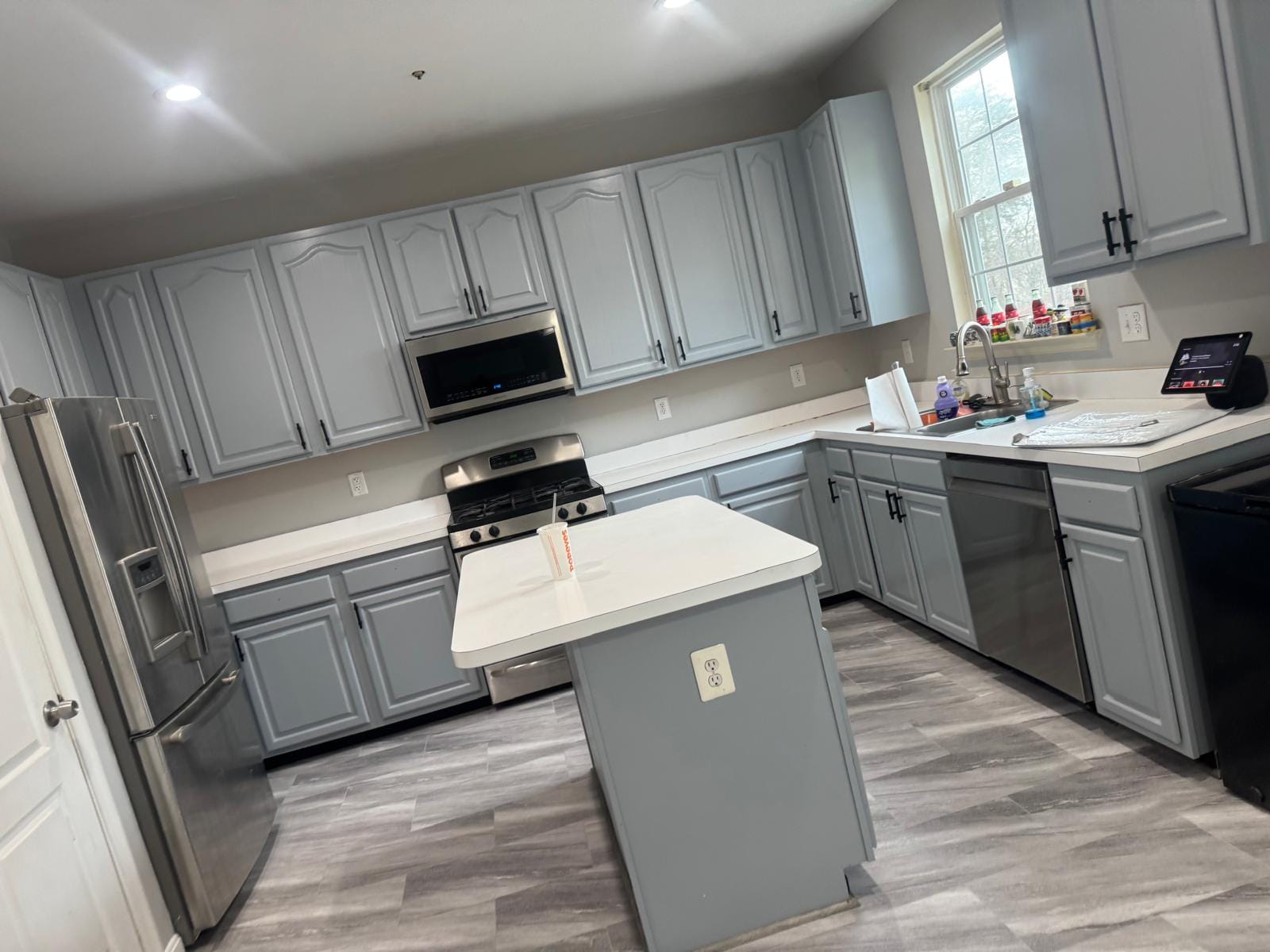 Kitchen remodel by Felipe Construction LLC: gray cabinets, white island, vinyl plank floor