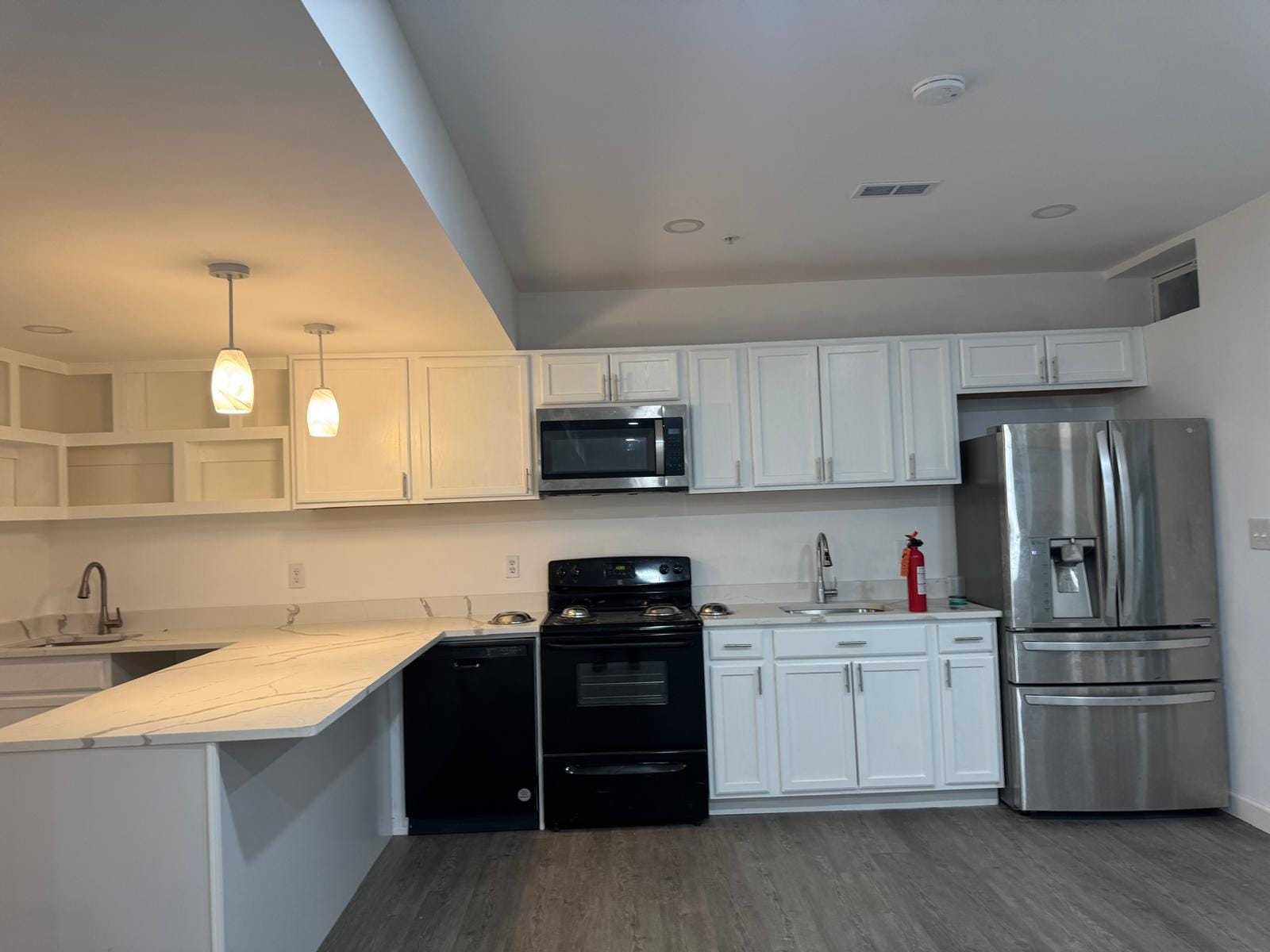 Finished kitchen with white cabinets and pendant lights